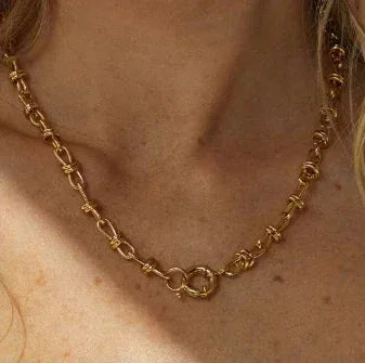 Woman wearing an elegant 18K gold-plated chain necklace with unique link design