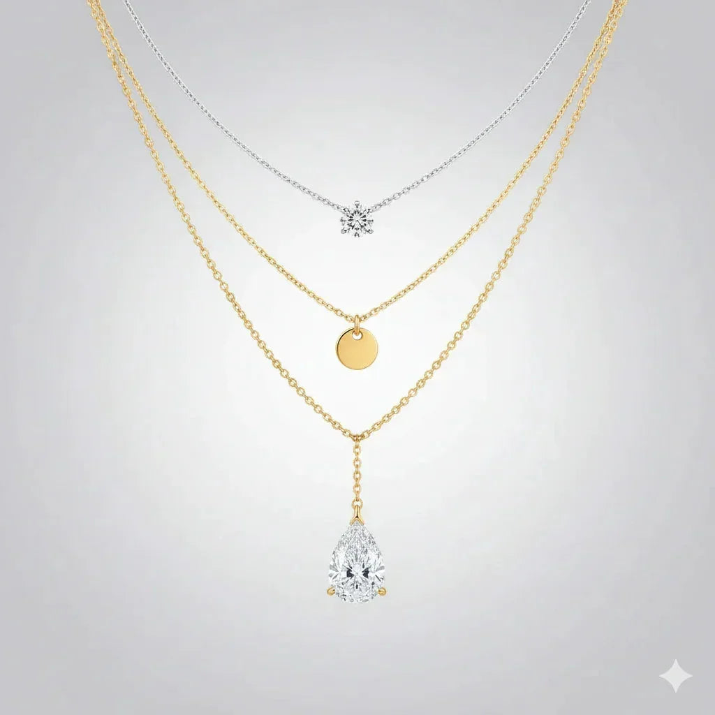 Layered necklace set with silver and gold chains featuring a snowflake, gold disc, and pear-shaped crystal pendants, elegant jewelry for women.