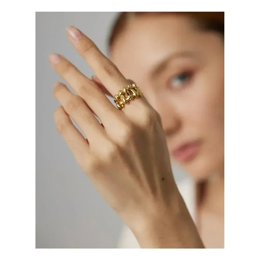 Woman wearing chunky gold-plated link ring, showcasing elegant jewelry style