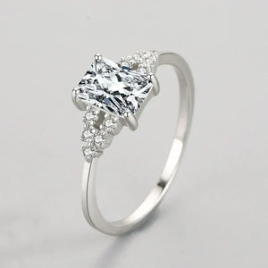 Elegant silver ring with a rectangular clear gemstone and small accent stones on band