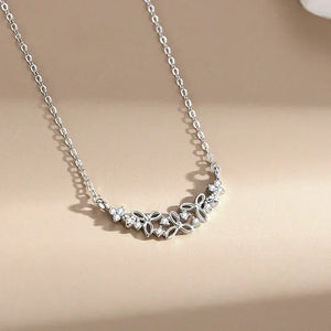 Silver necklace with floral design on a beige background