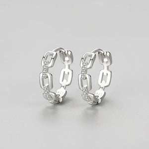 Pair of silver hoop earrings on a light gray background