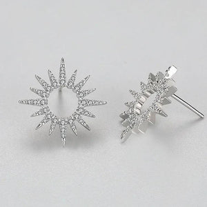 Pair of silver star-shaped earrings on a light gray background