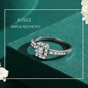 Silver ring with gemstones on a green surface with floral decorations