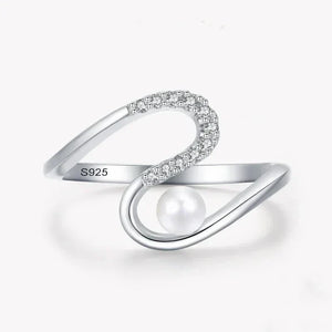 Sterling silver open ring with cubic zirconia and pearl accent on white background