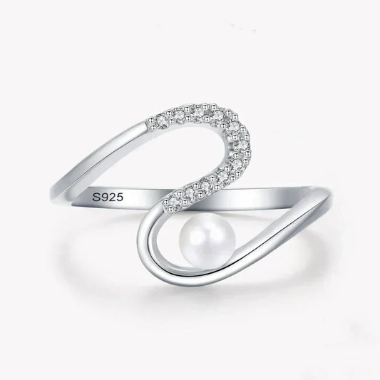 Sterling silver open ring with cubic zirconia and pearl accent on white background