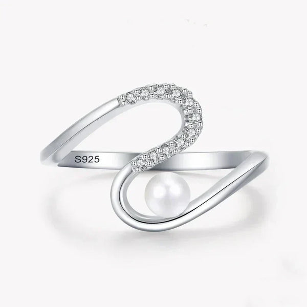 Sterling silver open ring with cubic zirconia and pearl accent on white background