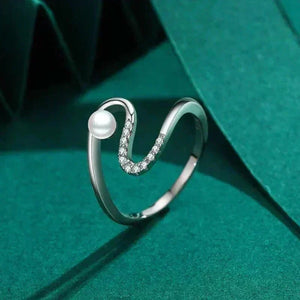 Silver ring with a pearl on a green fabric background