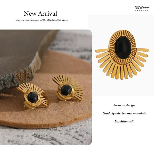 Gold earrings with black centers on a stone surface, with 'NEW++' branding.