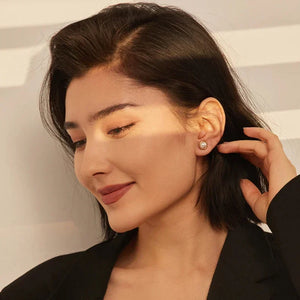 Woman adjusting her hair with a neutral background