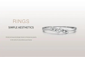 Minimalist silver ring with small sparkling gemstones on clean white background