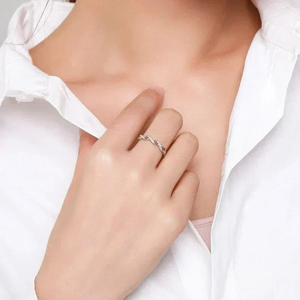Hand wearing a twisted 925 silver ring, styled with a white collared shirt.