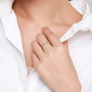 Woman wearing twisted 925 silver ring on finger, dressed in white shirt, elegant jewelry
