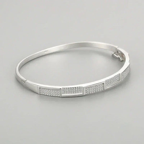 Elegant 925 silver bangle bracelet with rectangular pave-set crystal accents on gray background