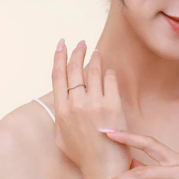 Woman wearing a delicate 925 silver curve ring with small stones on her finger