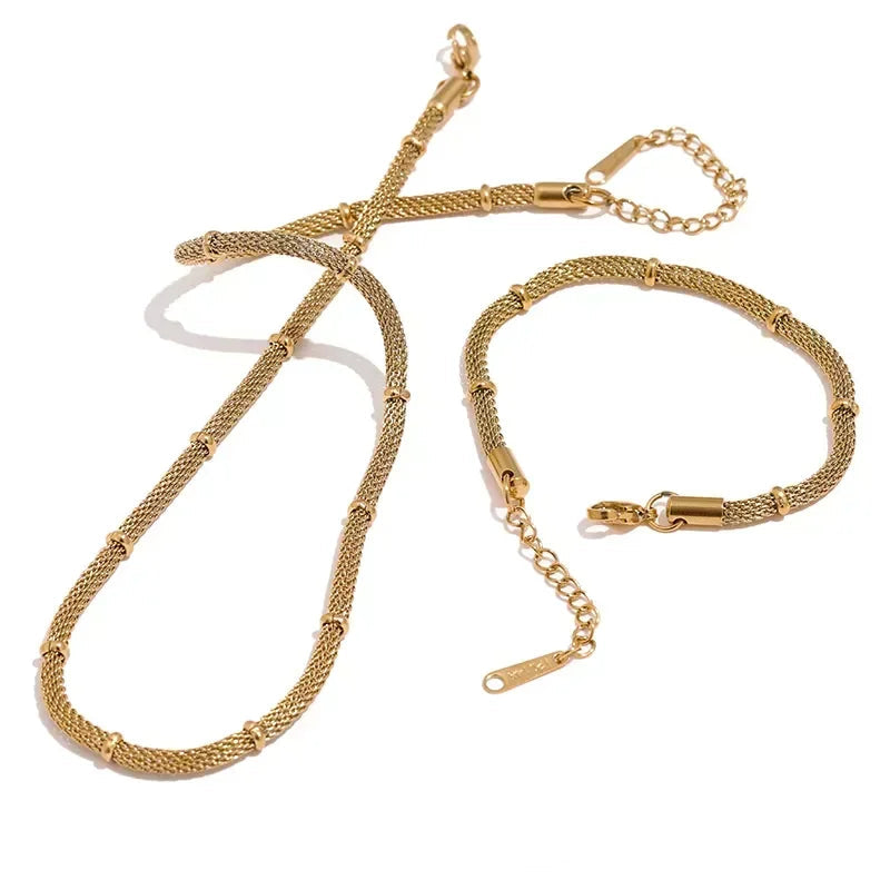 Gold necklace and bracelet set on a white background.