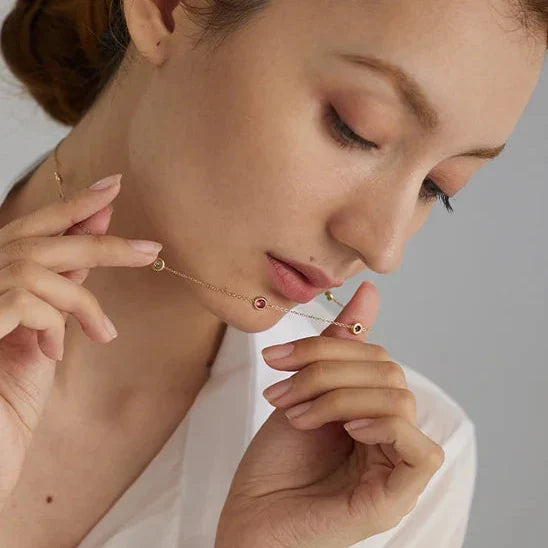 Woman wearing earrings with a minimalistic background and 'Y' brand logo.
