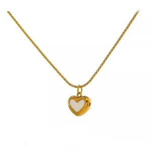 Gold necklace with a heart-shaped pendant on a white background