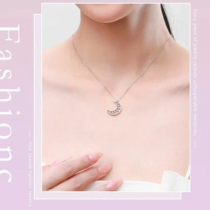 Necklace with a moon pendant worn by a person on a light pink background