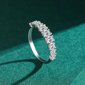 Silver ring with diamonds on a green background