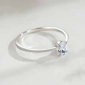 Sterling silver solitaire ring with oval-cut clear gemstone on a white surface