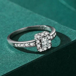 Silver ring with gemstones on a green textured surface