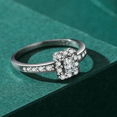 Silver ring with gemstones on a green textured surface
