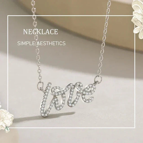 Silver necklace with 'love' pendant on a light background