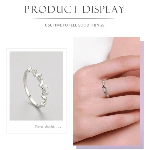 Silver ring with decorative elements displayed on a hand against a white background