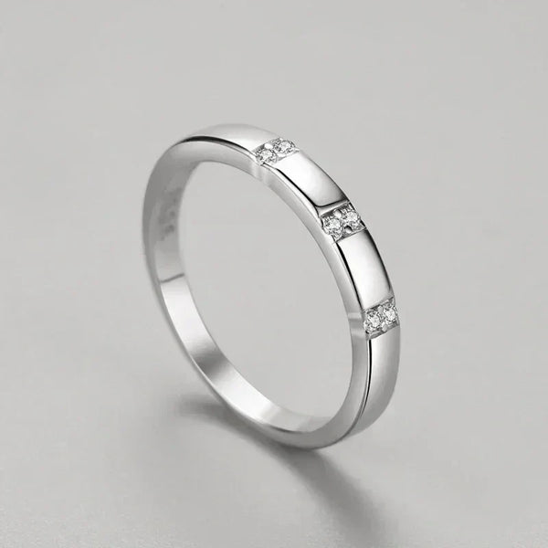 Silver ring with small diamonds on a gray background