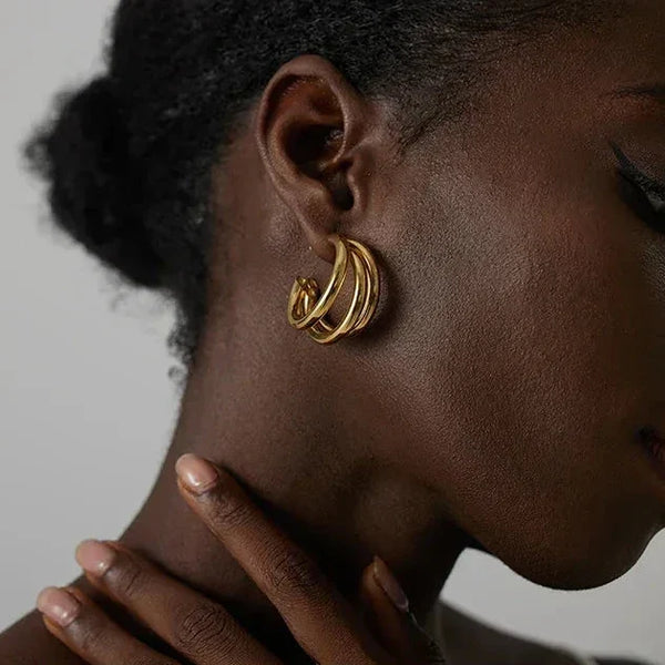 Woman wearing elegant gold-plated hoop earrings, close-up jewelry photography