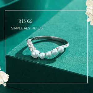 Silver ring with pearls on a green background