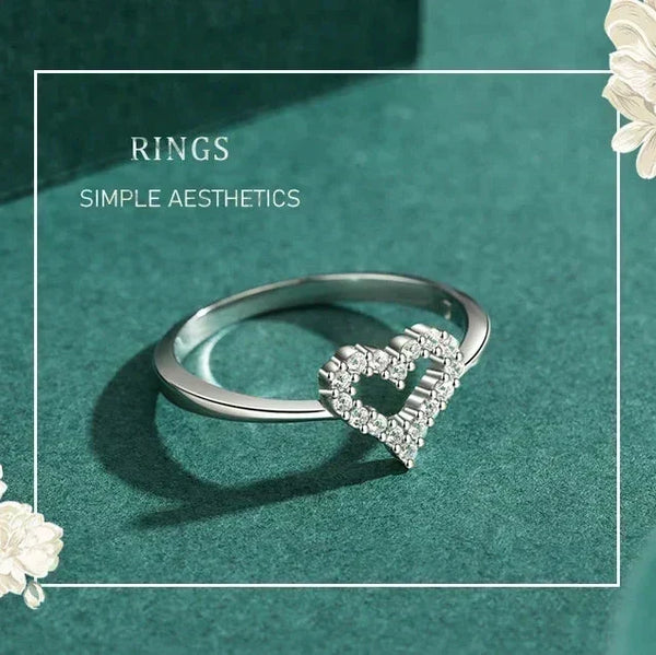 Silver ring with heart design on a teal background TM & CO. JEWELS 