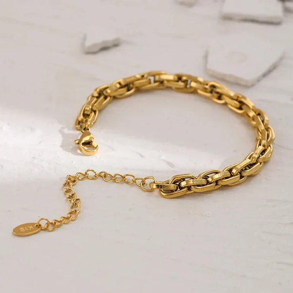 Gold chain bracelet on a light gray background