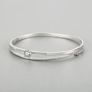Elegant 925 silver bangle bracelet with sparkling cubic zirconia accents on a gray background