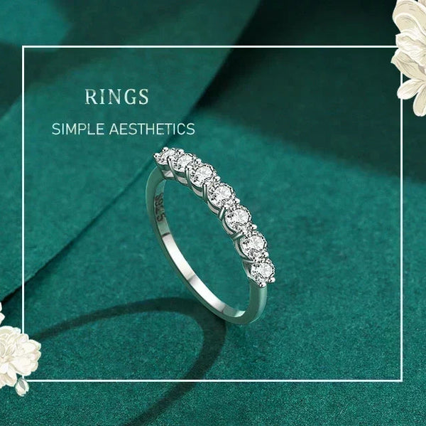 Silver ring with diamonds on a teal background with floral elements