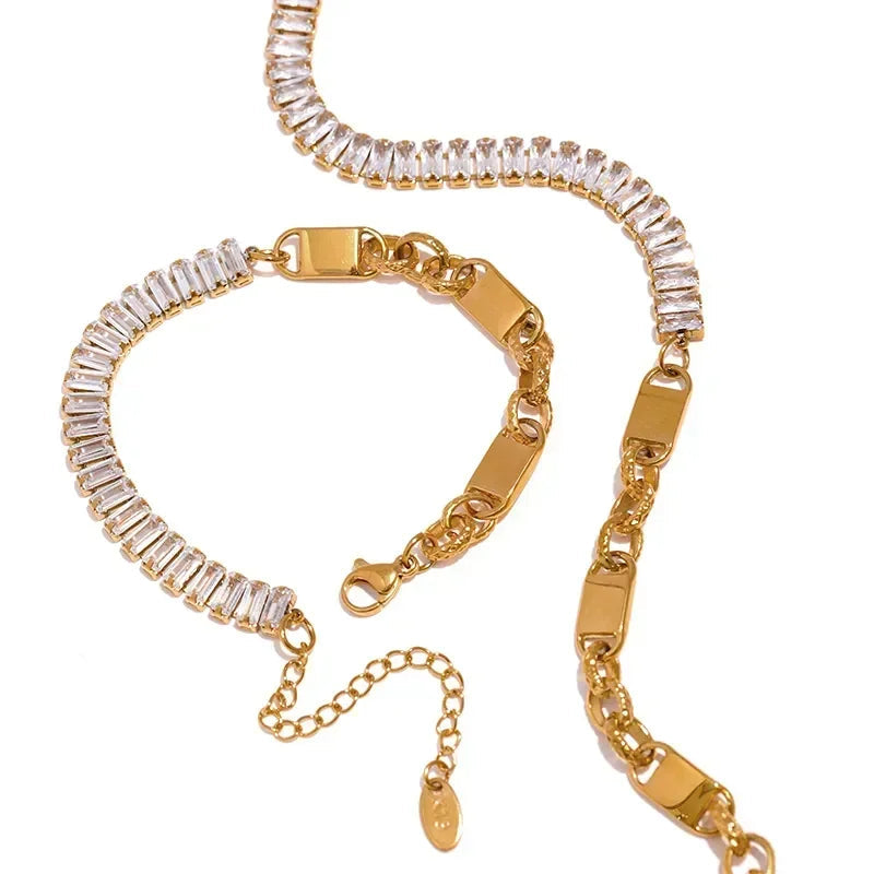 Gold bracelet with clear gemstones on a white background.