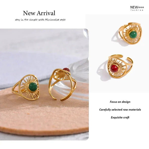 Gold rings with green and red stones on a white background