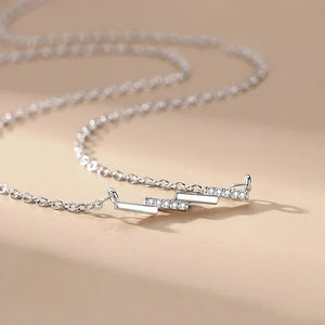 Silver necklace with a unique design on a beige background