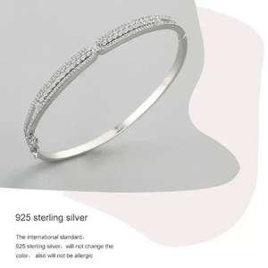 Silver bracelet on a light gray background with text about 925 sterling silver.