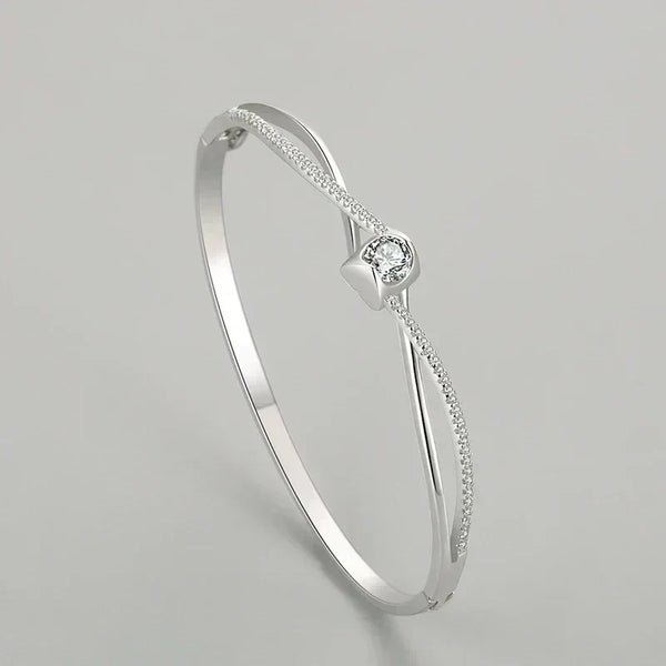 Silver bracelet with a central diamond on a light gray background
