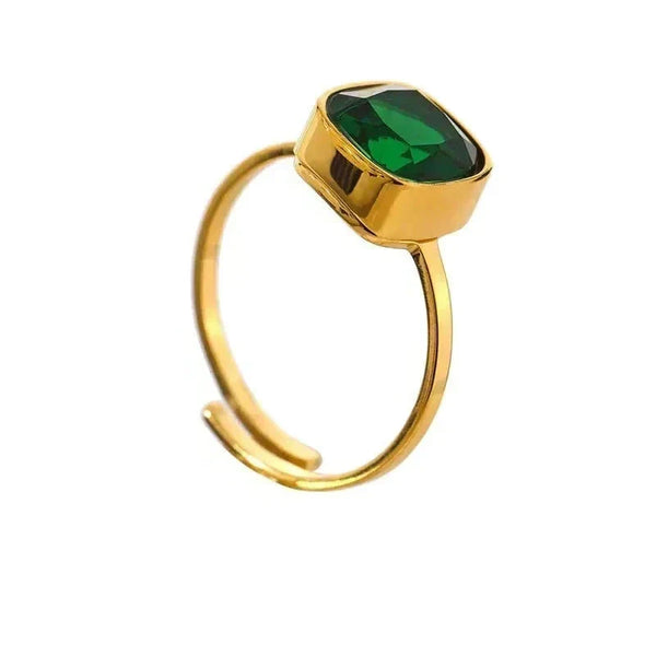 Gold ring with a green gemstone on a white background