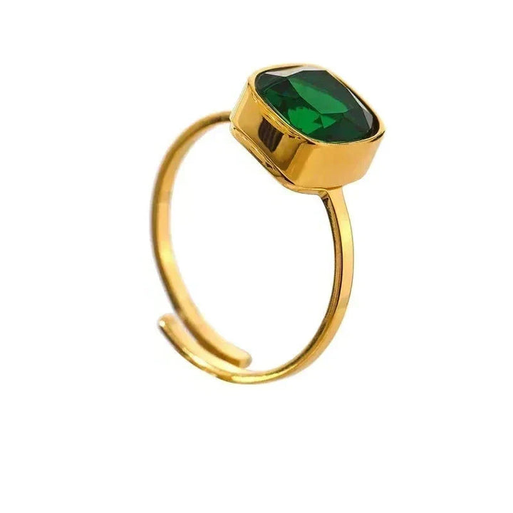 Gold ring with a green gemstone on a white background