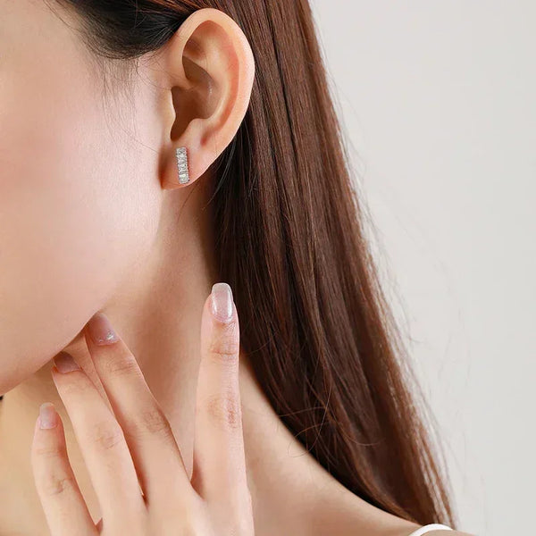Woman wearing a rectangular 925 silver and cubic zirconia stud earring