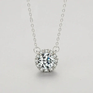 Silver necklace with a diamond pendant on a light gray background.