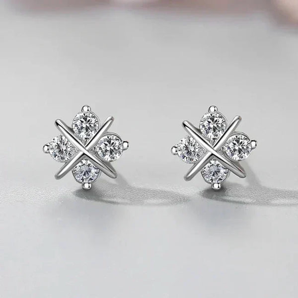 Pair of silver earrings with a star design on a light gray background