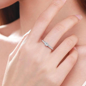 Hand wearing a 925 silver solitaire ring with a round center stone and side accents