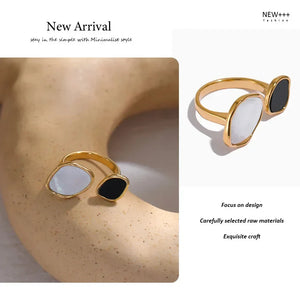 Gold-plated adjustable ring with black and white stones on textured surface