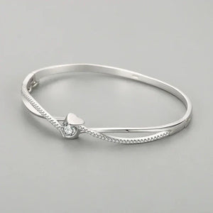 Silver bracelet with a heart-shaped clasp on a gray background