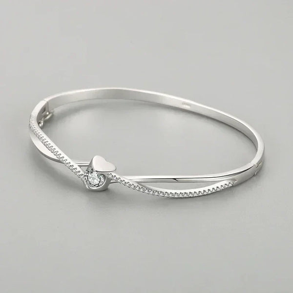 Silver bracelet with a heart-shaped clasp on a gray background